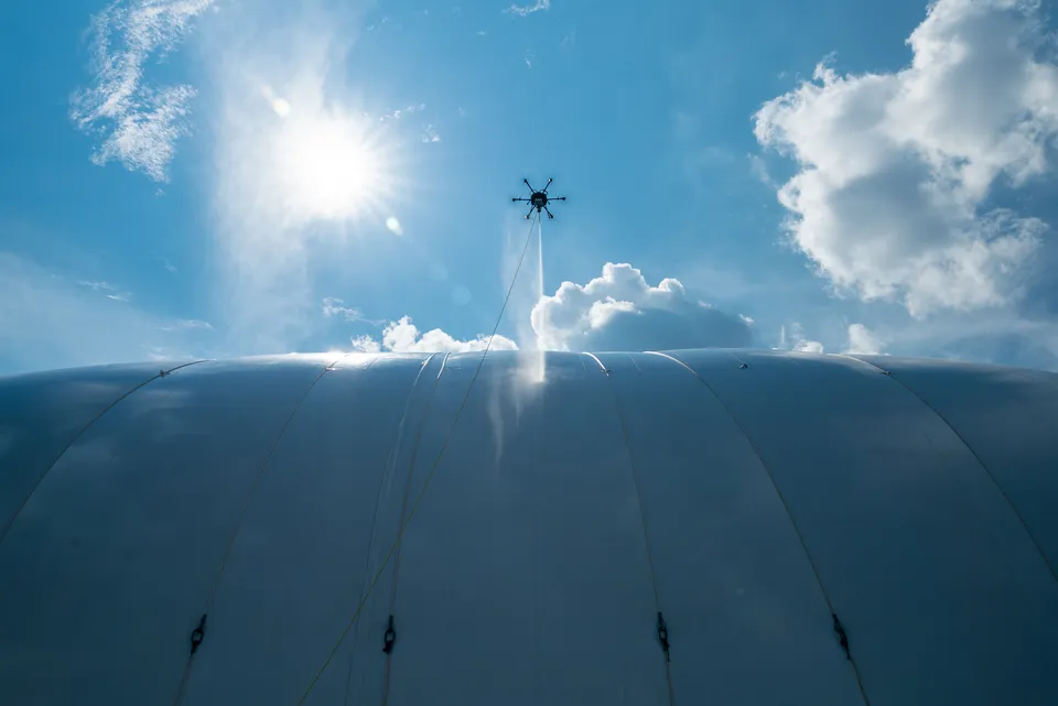 Drone soft washing the exterior of an NFL team training facility