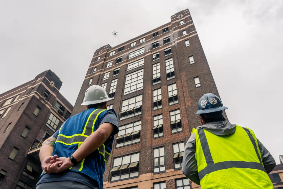 Drone cleaning the exterior of a historic industrial refinery building